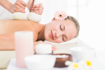 Fototapeta na wymiar Beautiful blonde enjoying a herbal compress massage
