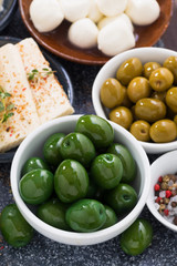 snacks - green olives and soft cheeses, vertical, top view