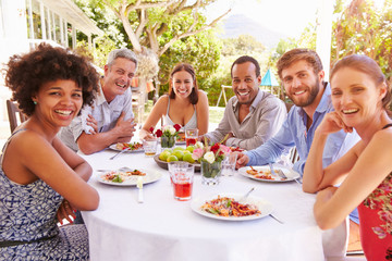 Friends dining together at a table in a garden