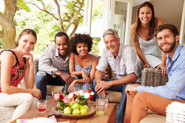 Group portrait of friends socialising in a conservatory