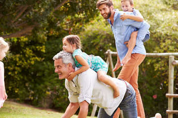 Fototapeta premium Two men playing with kids in a garden