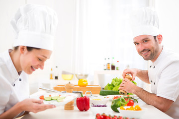Young attractive professional chef cooking in his kitchen