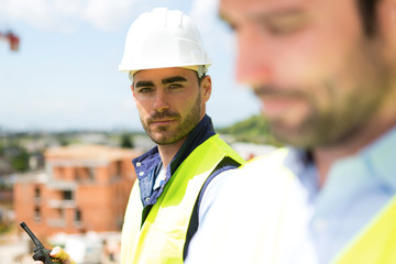 Portrait of an attractive worker on a construction site - obrazy, fototapety, plakaty