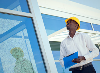 Worker inspector  in helmet checking  modern building  