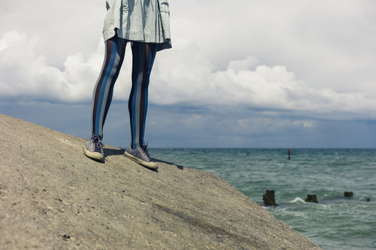 Legs of young woman standing by coast