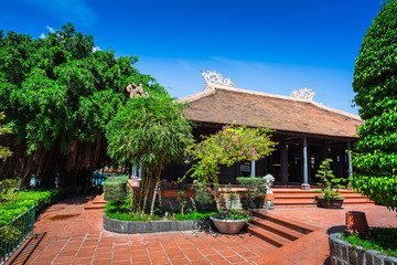 Vietnamese courtyard with trees, a fountain and houses covered w