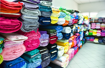 Rolls of fabric and textiles in a factpory shop.