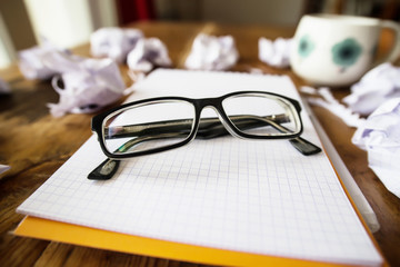 Travailler beaucoup: les lunettes sur un cahier