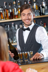 Handsome bartender making shots