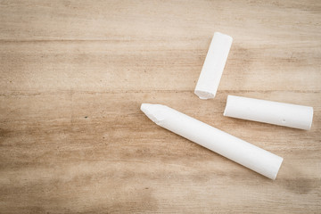 Close up of white chalk on wooden desk