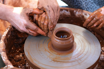 Hands working on pottery wheel
