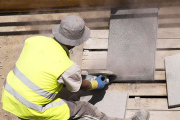 construction  worker cutting tiles with electric grinder