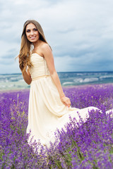 Pretty girl is wearing wedding dress at purple lavender field