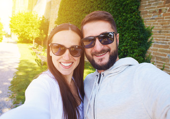 couple in sunglasses taking selfie