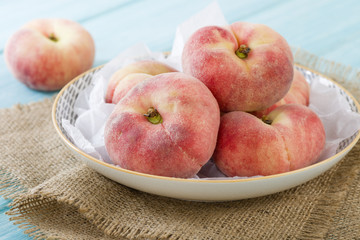 Saturn Peach - Doughnut peaches on a blue background.
