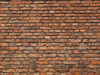 Medieval rough brick wall of earth and terracotta colored bricks in Delft
