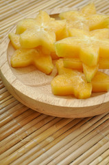 Vertical shot of starfruit on a wooden plate
