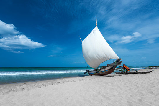 Fototapeta Beautiful canves boat in the beach in hot sunny day