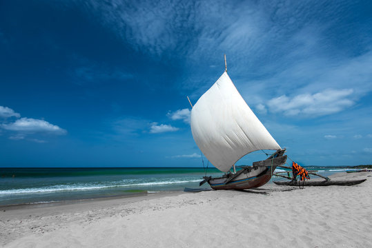 Fototapeta Beautiful canves boat in the beach in hot sunny day