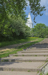 The path to the white stone Orthodox church on a hillside.