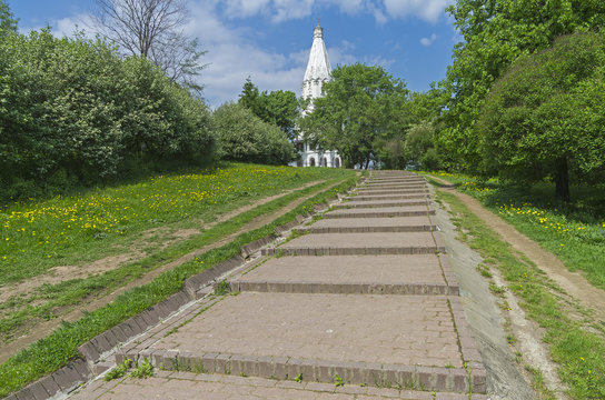 The path to the white stone Orthodox church on a hillside.