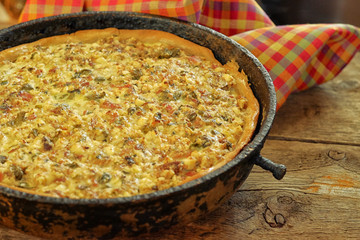 Quiche pie with chicken, green pepper, ham and mushroom  in blac
