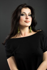 Naklejka premium Attractive brunette on a black background. Portrait of a beautiful woman. 
