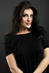 Fototapeta na wymiar Attractive brunette on a black background. Portrait of a beautiful woman. 