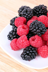 Blackberry and raspberries on white plate