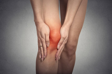 tendon knee joint problems on woman leg indicated with red spot