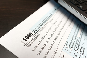 Obraz premium US Individual Tax Return Form 1040 on a table next to laptop computer