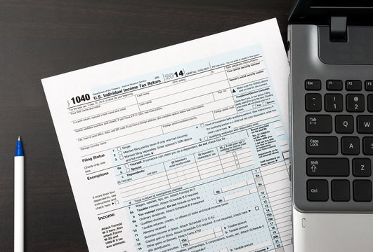 US Individual Tax Return Form 1040 On A Table Next To Laptop Computer