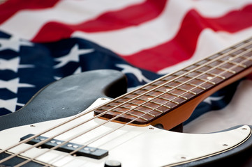 Fototapeta na wymiar Vintage Bass guitar body on american flag background. selective focus image with shallow depth of field