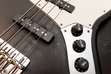 Classic black and white bass guitar body close up. color image