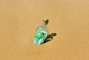 Vieja botella de cristal con um billete de 100 euros encontrada en la playa