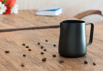 Black milk pitcher on wood table