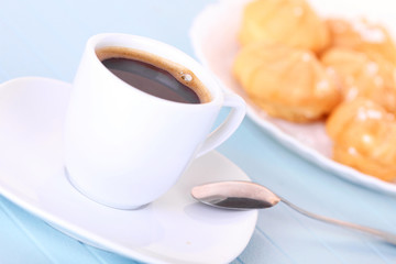 Cup of coffee and cakes on white plate