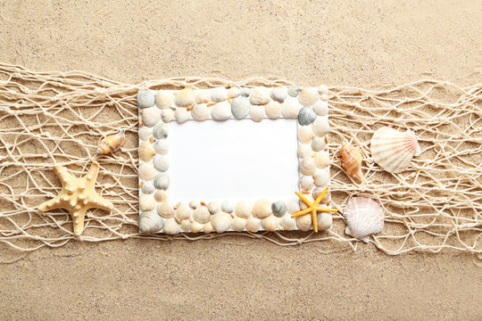 Frame of sea shells on beach sand