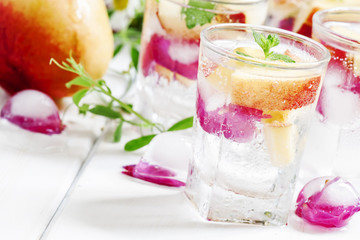 Fresh sparkling beverage with peaches and ice with rose petals o