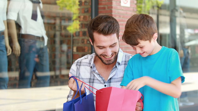 Father and son looking in shopping bag