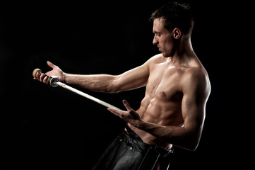 Ancient  muscular warrior gladiator with sword on black background