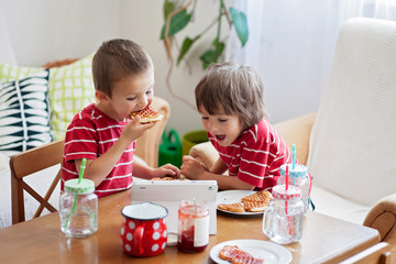 Obraz na płótnie Canvas Two happy kids, two brothers, having healthy breakfast sitting a