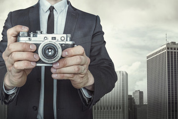Businessman taking a photo with vintage camera