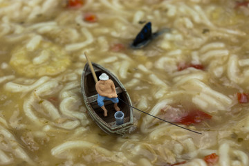 Miniature man fishing in soup