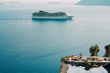 young couple sitting in a restaurant on the rocks near the sea i
