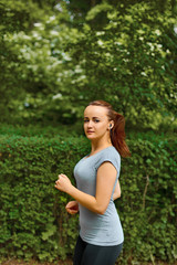 Young woman jogging in the park in summer