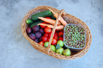 assorted raw organic vegetables and fruits in a basket