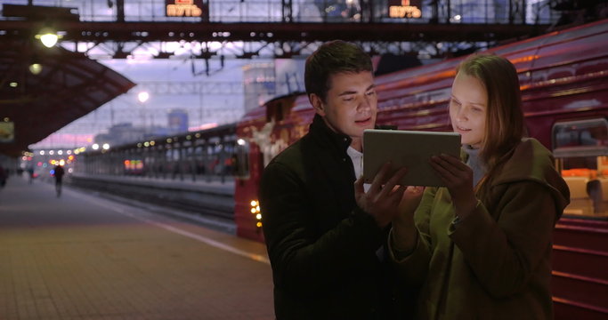Man and woman with pad at the station