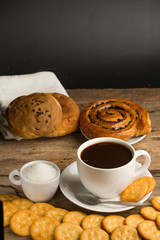 Cup of coffee on a wooden board and biscuits