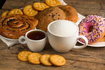 Cup of coffee on a wooden board and biscuits